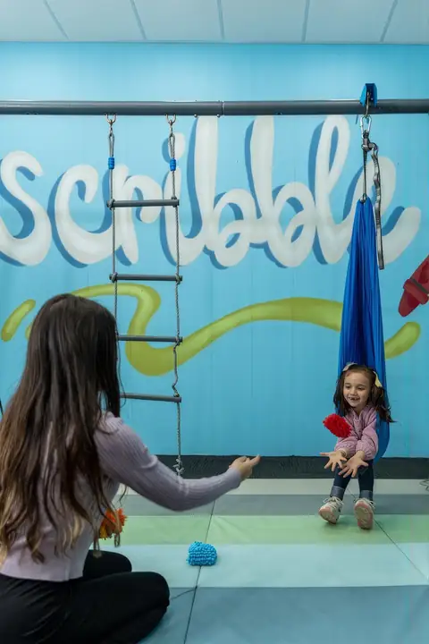 Swinging and reaching in the sensory room